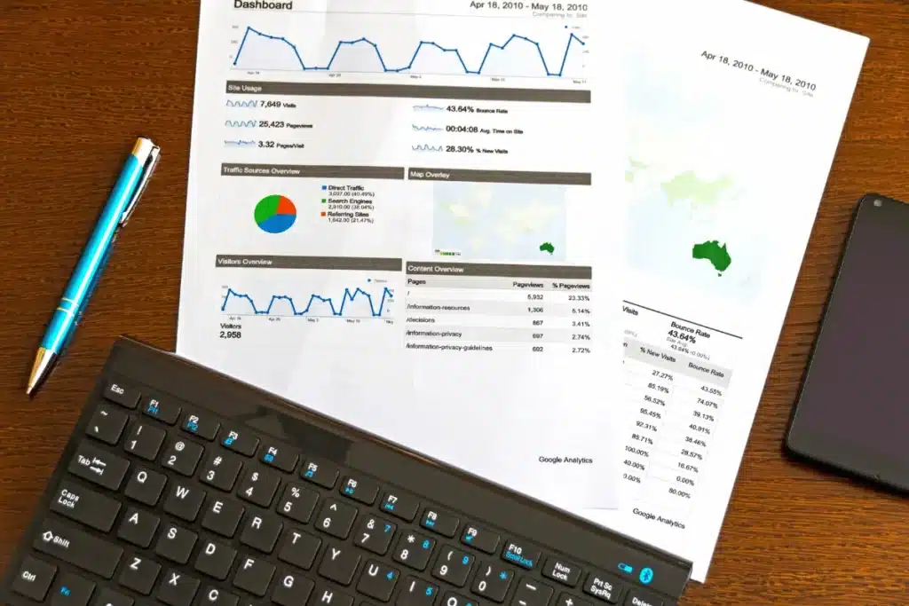 Close-up view of a business analytics report beside a sleek laptop and a stylish blue pen.