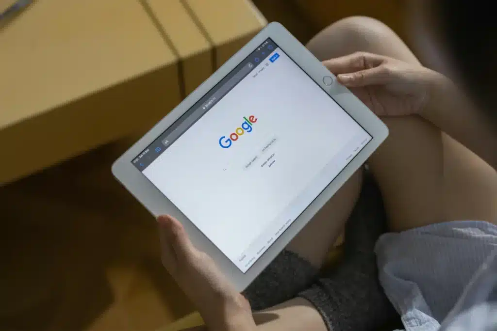 Person holding a tablet displaying the Google search homepage, emphasizing the ease of mobile web browsing.