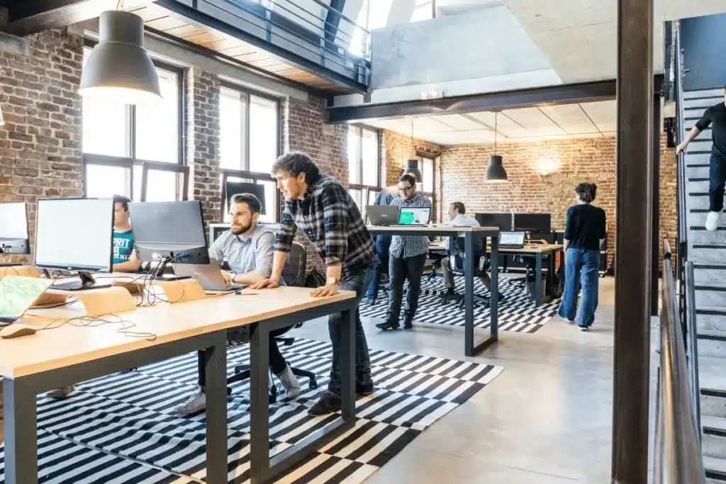 Team of programmers and designers collaborating in an industrial-style office.