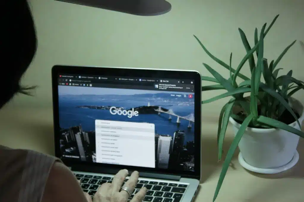 User engaged with Google search engine on a laptop in a minimalist office environment.