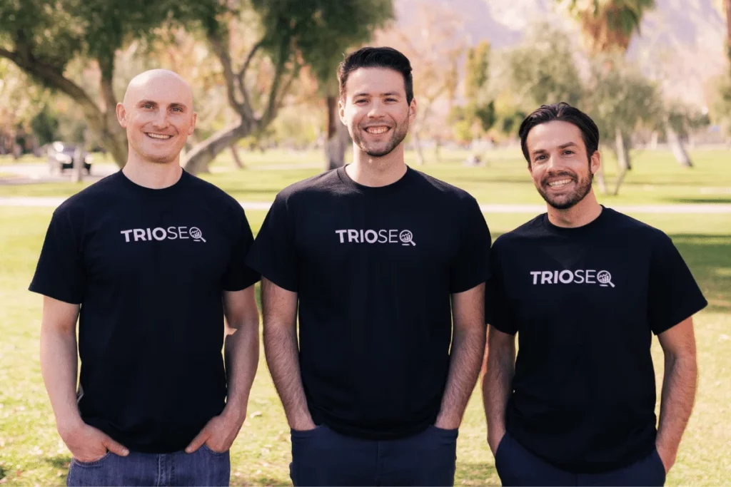 Nathan, Steven, and Connor in black t-shirts with "TRIOSEO" logos, standing outdoors in a park.