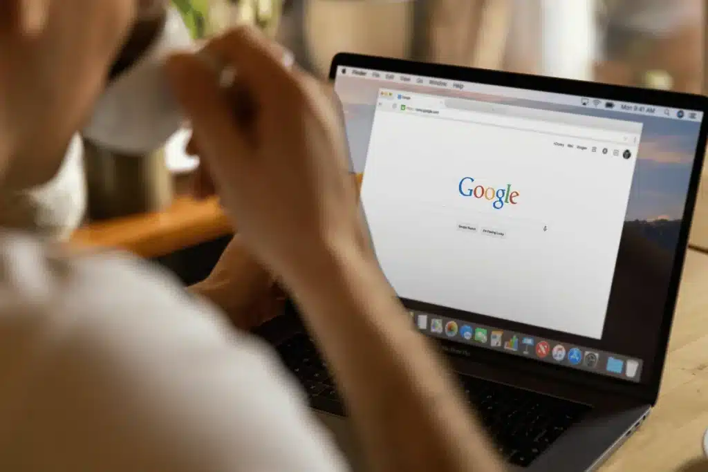 Over-the-shoulder view of a person using Google on a MacBook Pro.
