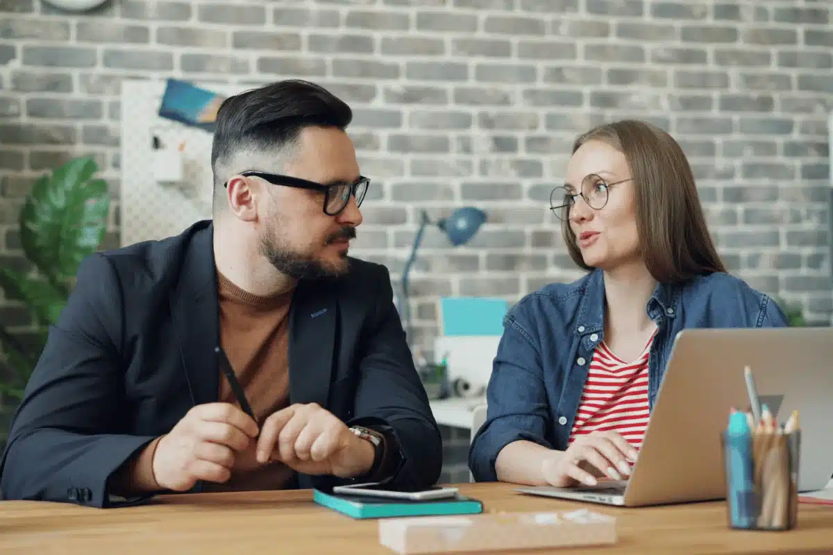 Man and woman collaborating on a project at a stylish home office with plants.
